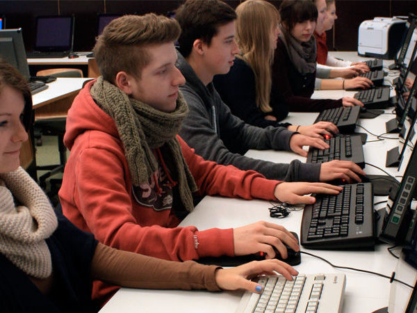 verschiedene Schülerinnen und Schüler beim Arbeiten an Rechnern in der Dr. Buhmann Schule & Akademie in Hannover