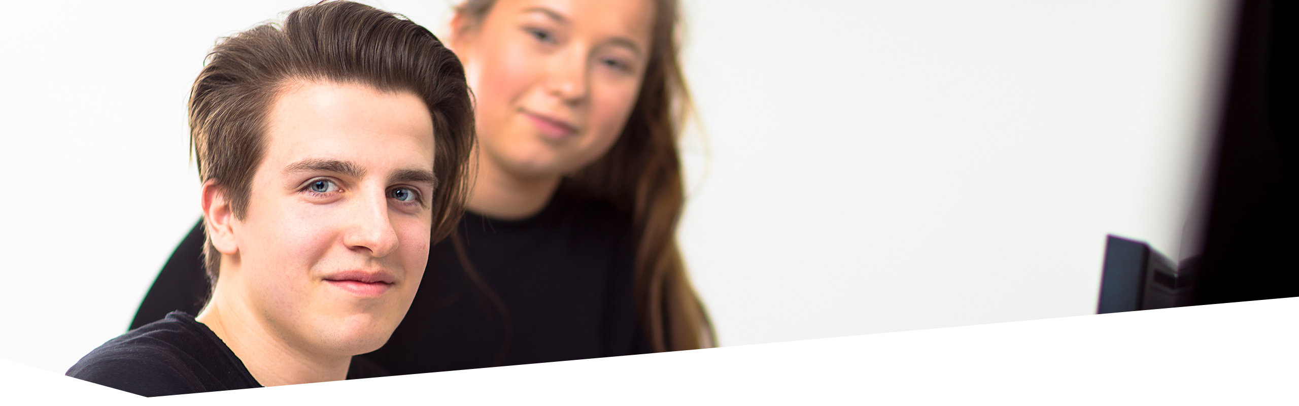 Schüler und Schülerin der Dr. Buhmann Schule und Akademie, die den Betrachter anlächeln