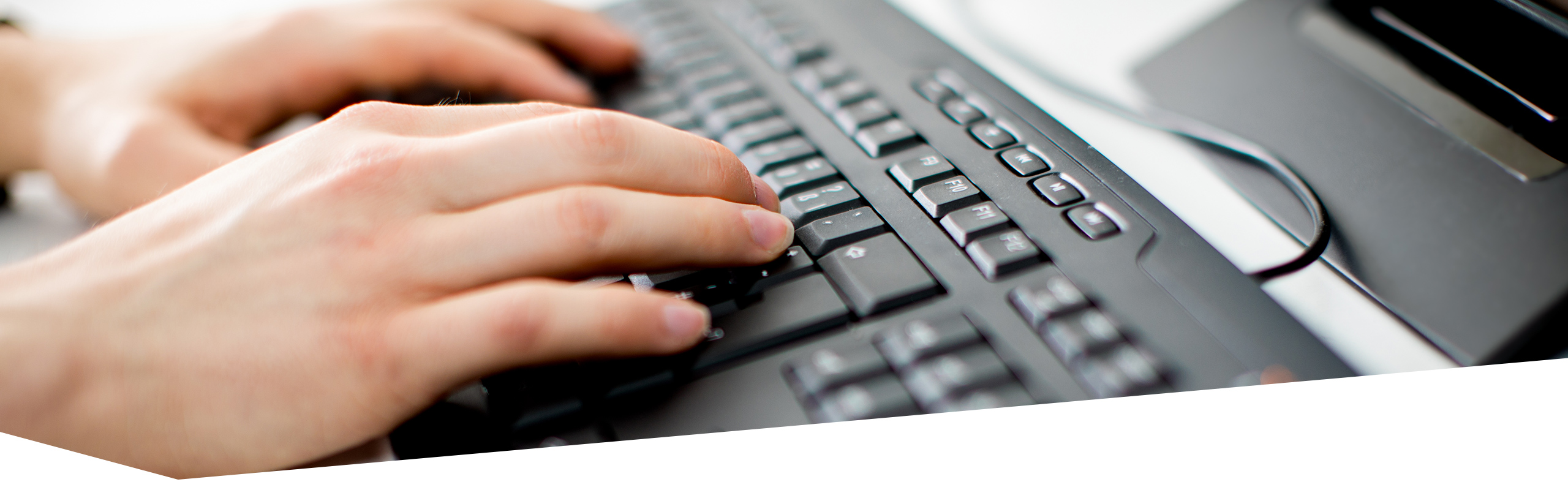 Nahaufnahme von tippenden Händen auf einer Computertastatur
